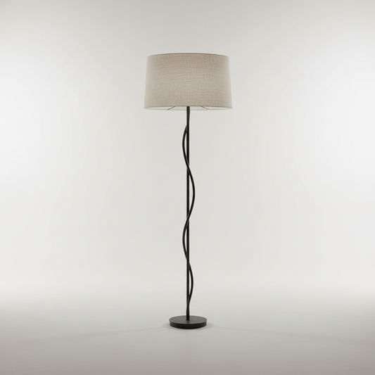 Sculptural matte black floor lamp with linen shade against pale studio background